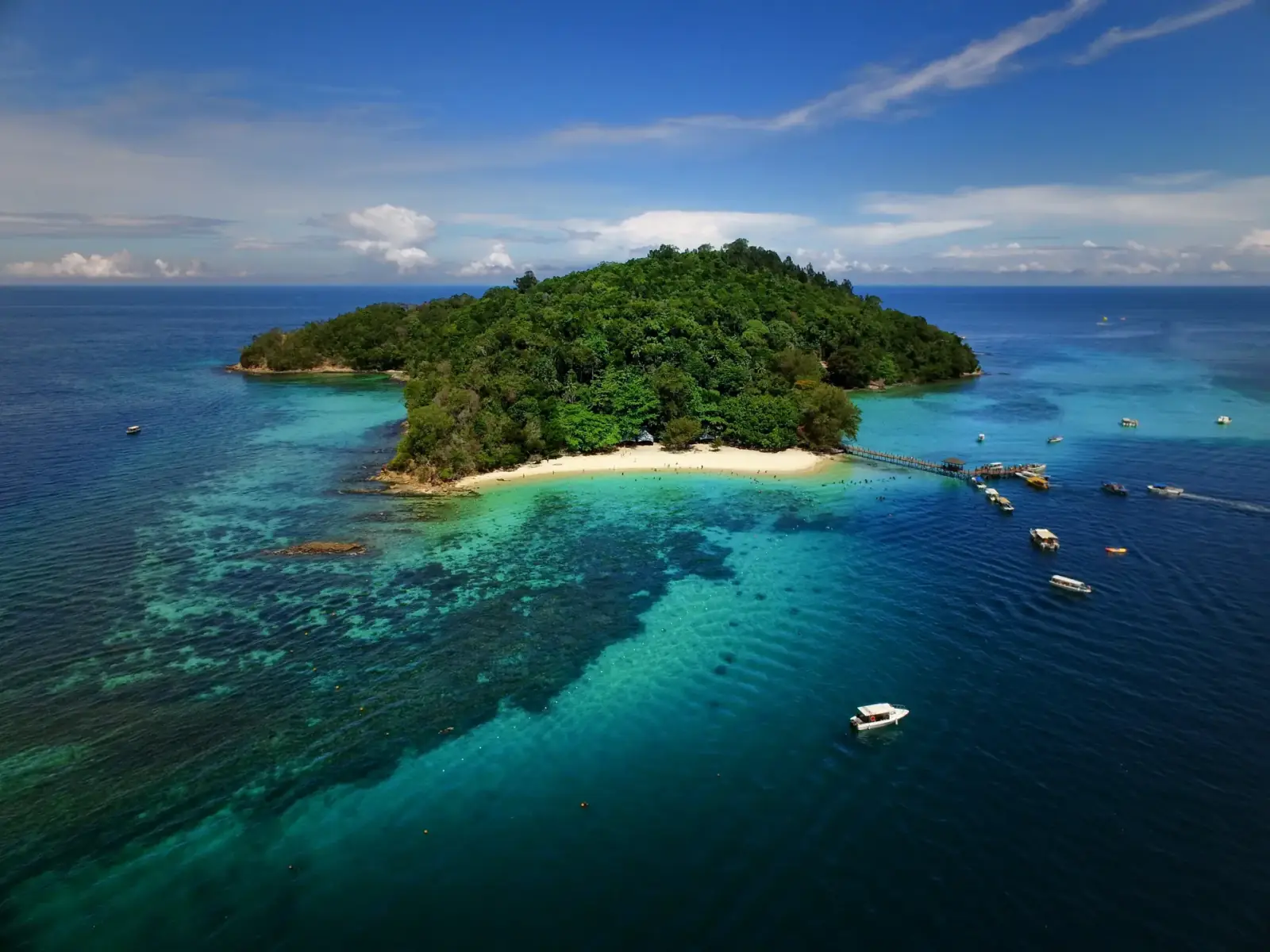 A green Sabah island surrounded by turquoise sea
