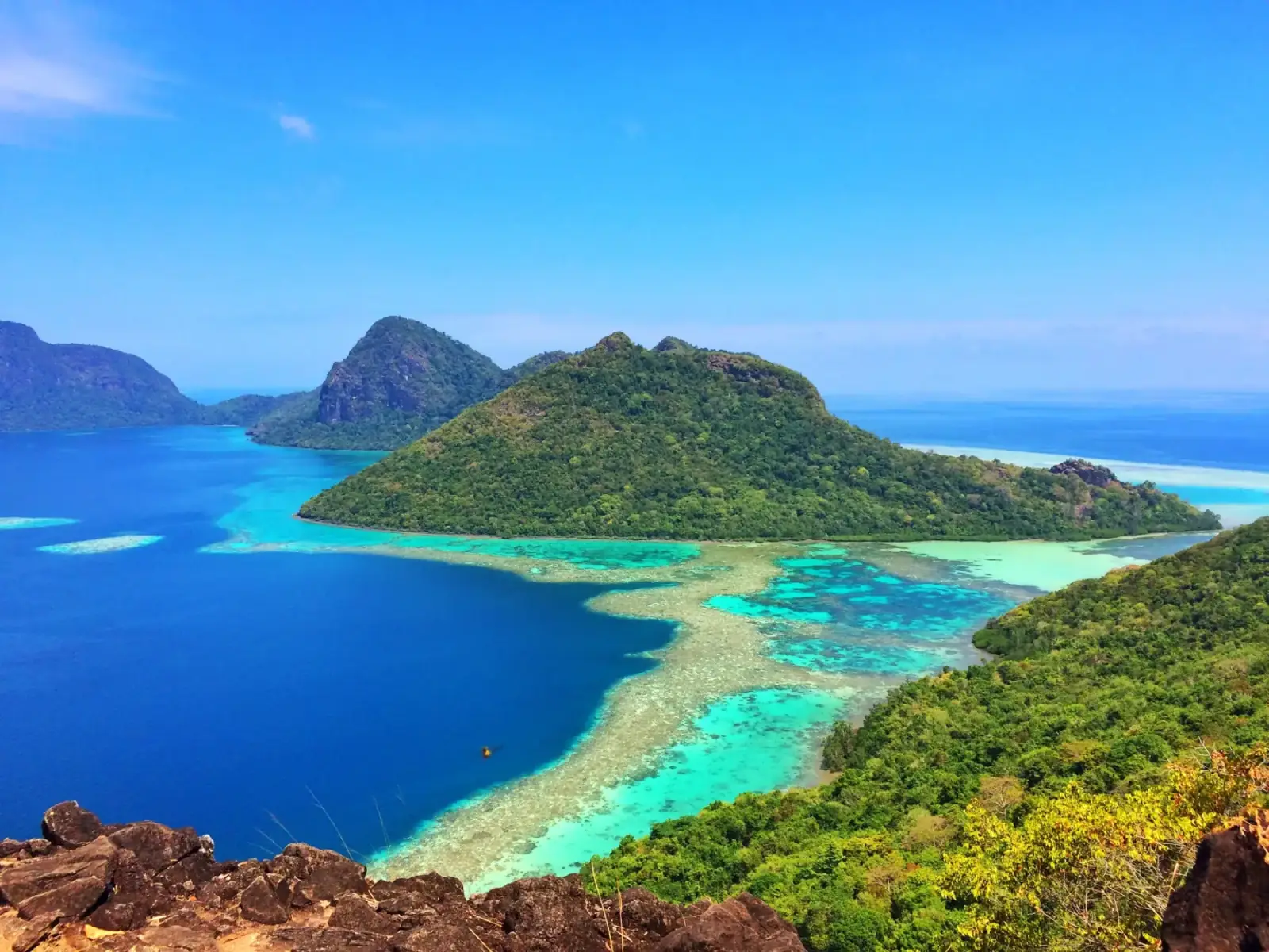 Turquoise reef flats and forested islands in Sabah's coral-rich waters